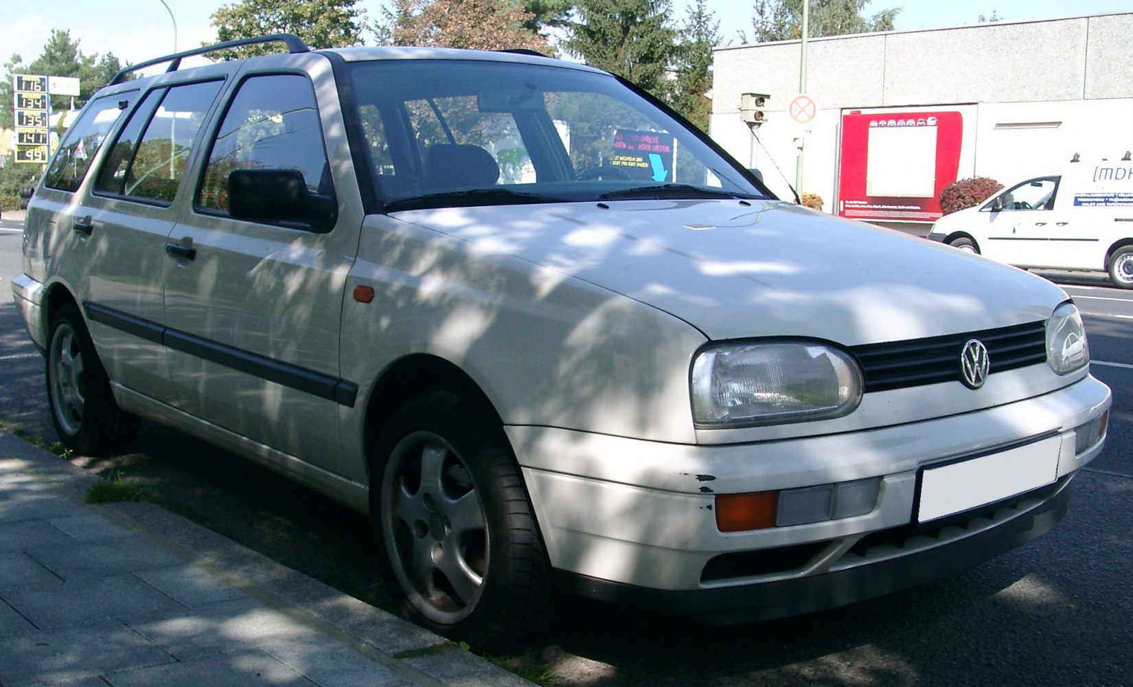 White station wagon with roof rails and front-side view