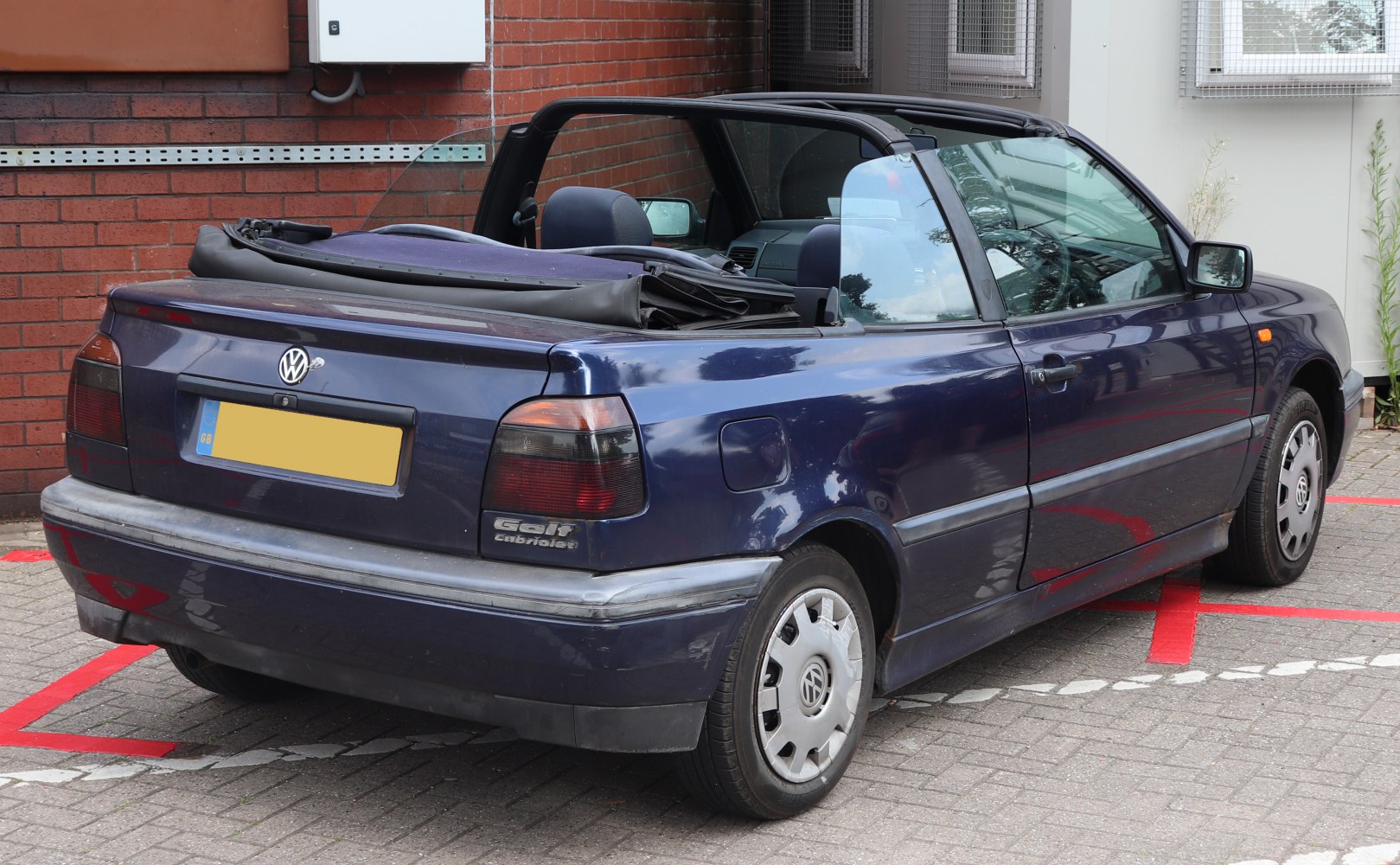 1990s convertible with folded roof showing rear and side view