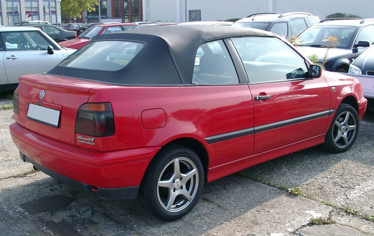 Red convertible with black fabric soft top and alloy wheels