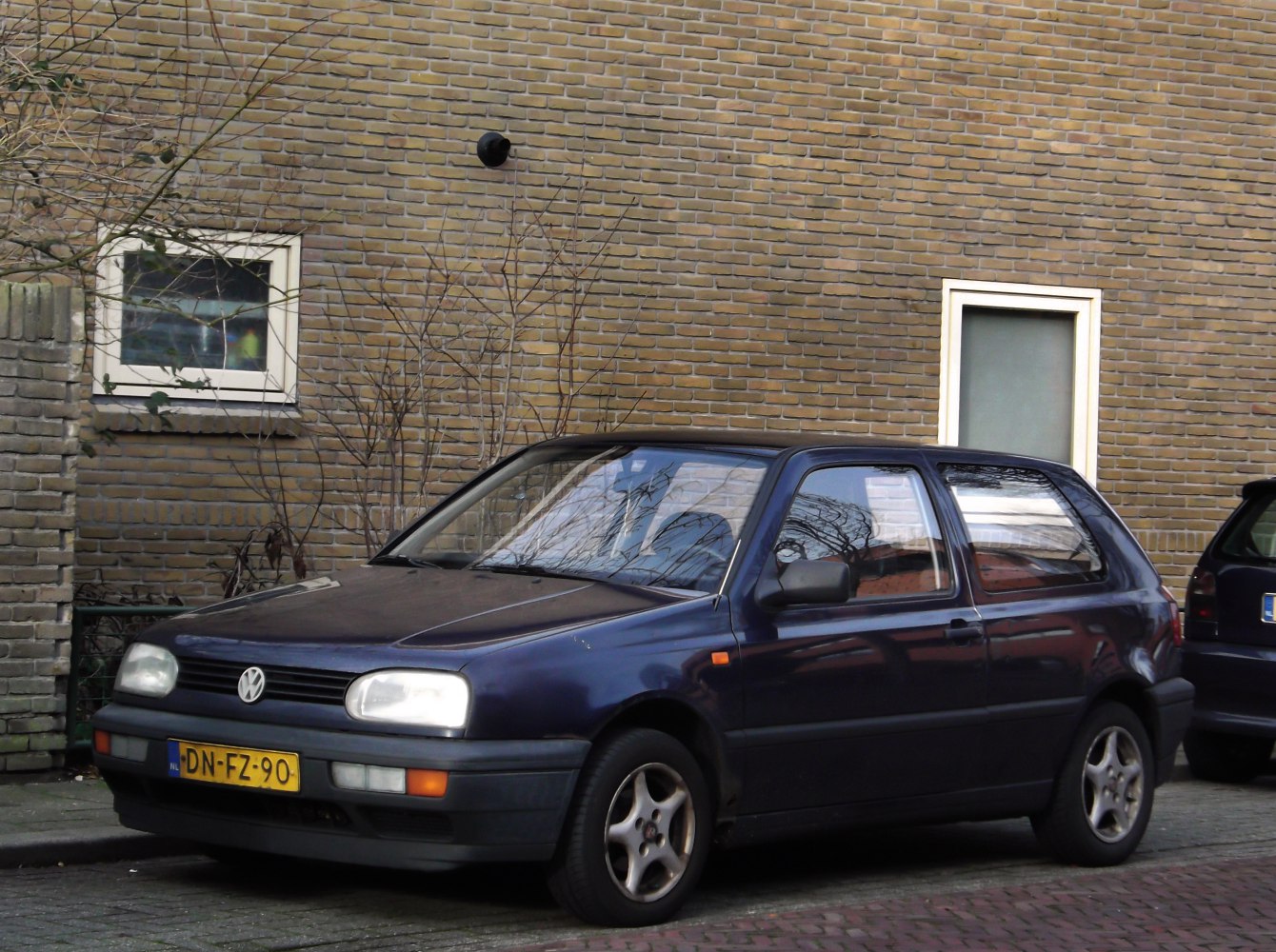 Rectangular headlights, simple grille, three-door compact hatchback.
