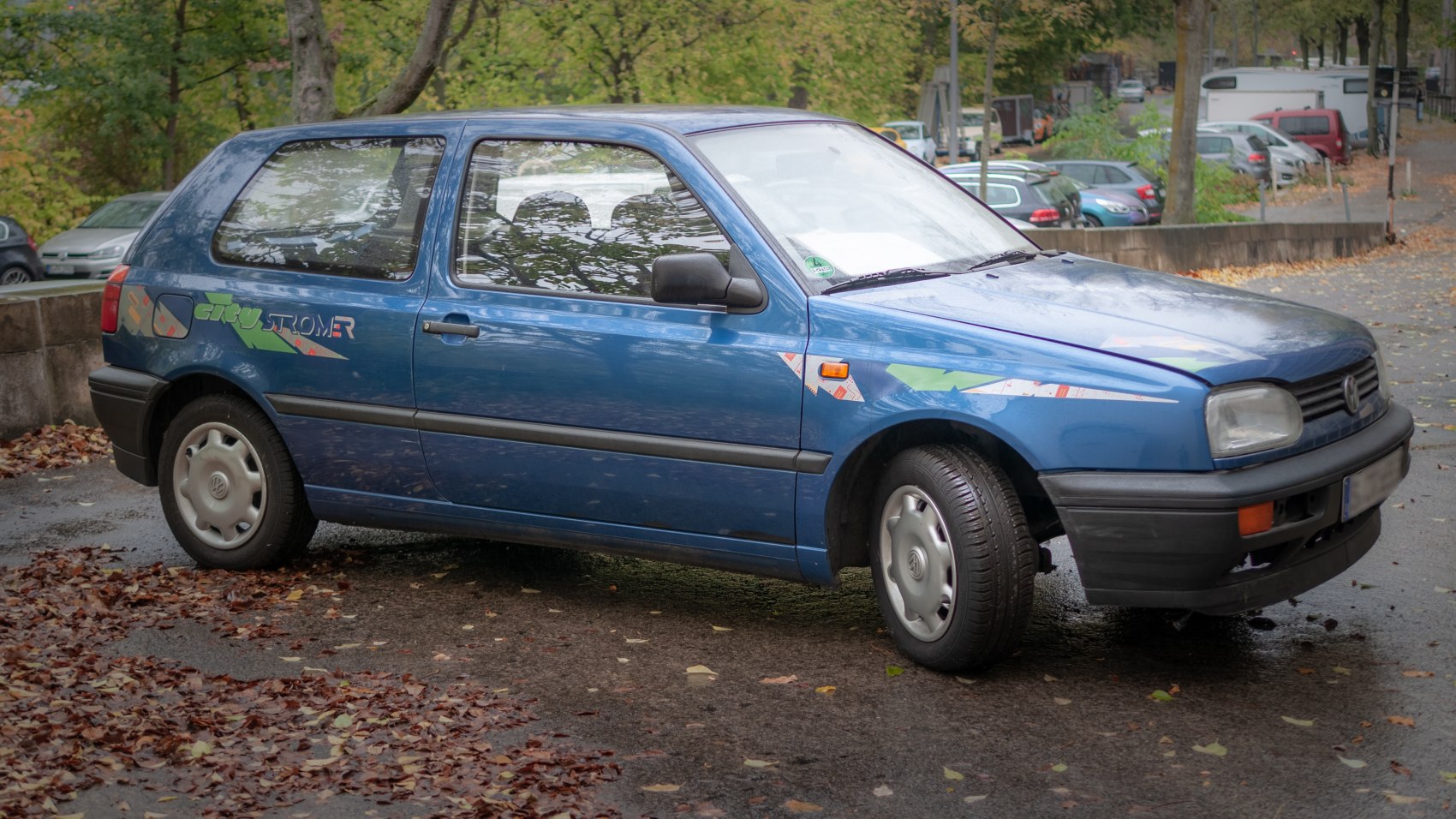 Blue hatchback with decals, black trim, and classic wheel covers