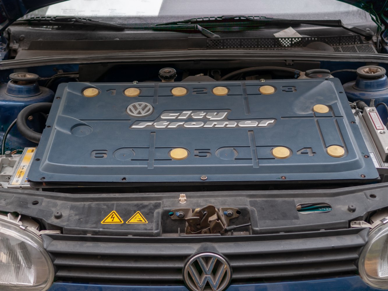 Close-up of engine bay with dirty stroker engine cover and VW emblem