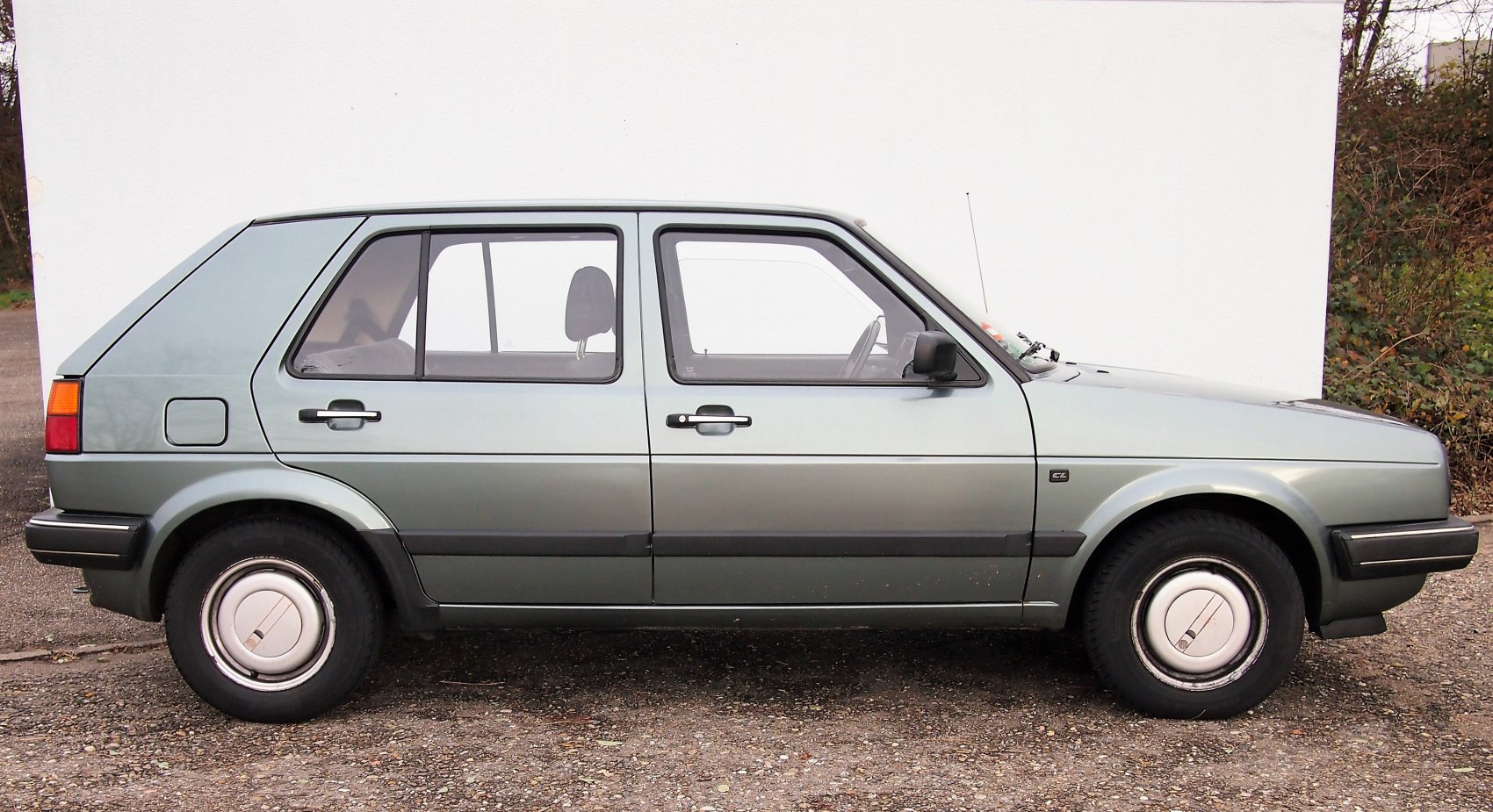 Side profile of vintage 5-door hatchback with boxy design and classic wheels