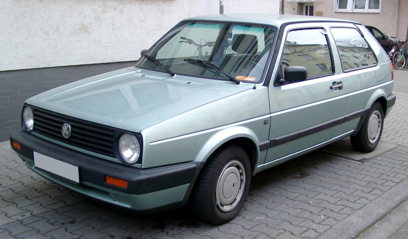 Front and side view of a 3-door compact hatchback featuring round headlights and classic grille