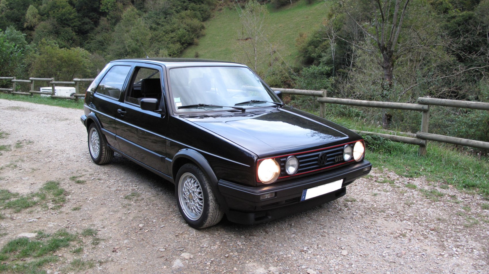 3-door compact hatchback with round headlights and mesh alloy wheels