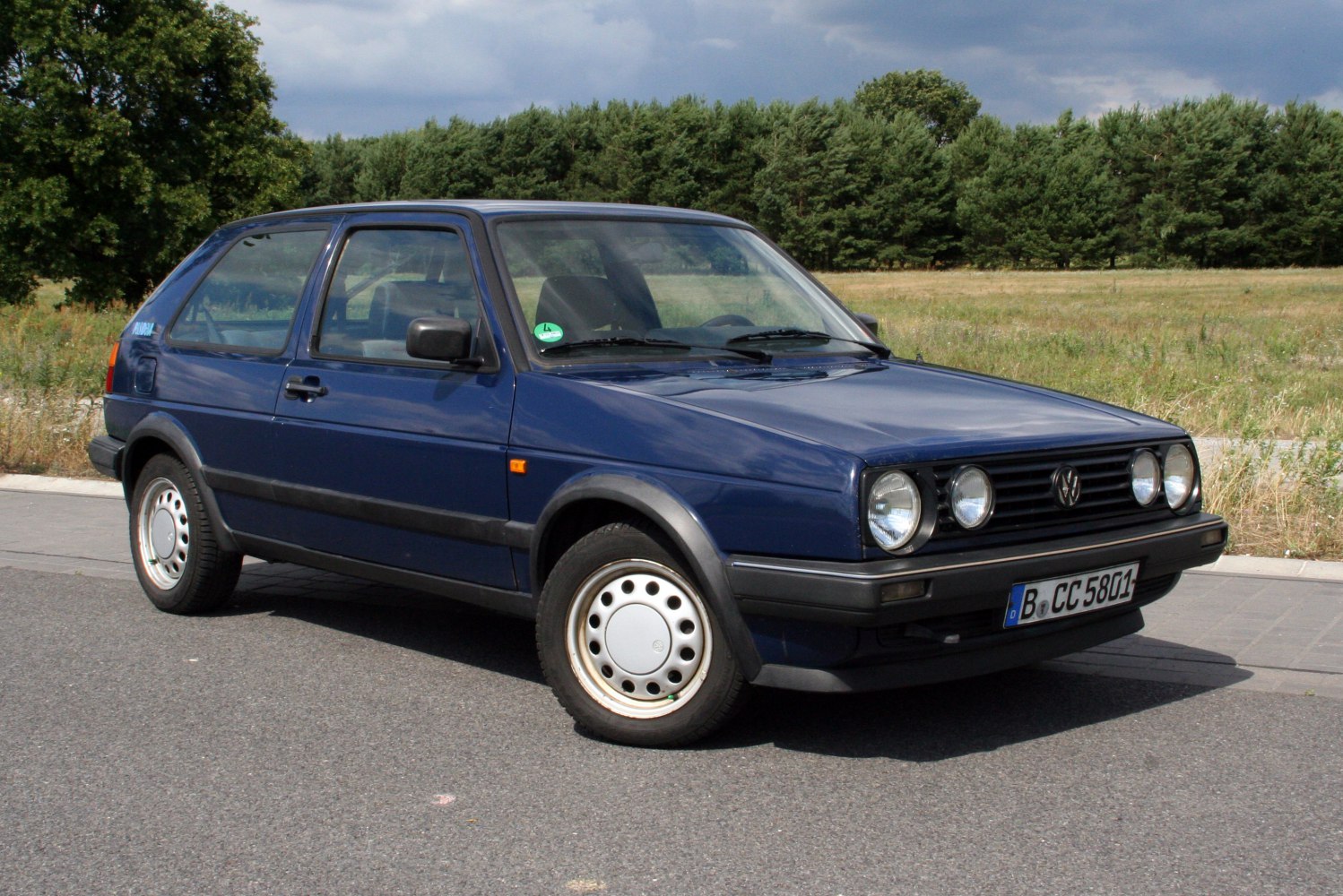 3-door hatchback with quad round headlights and black bumper