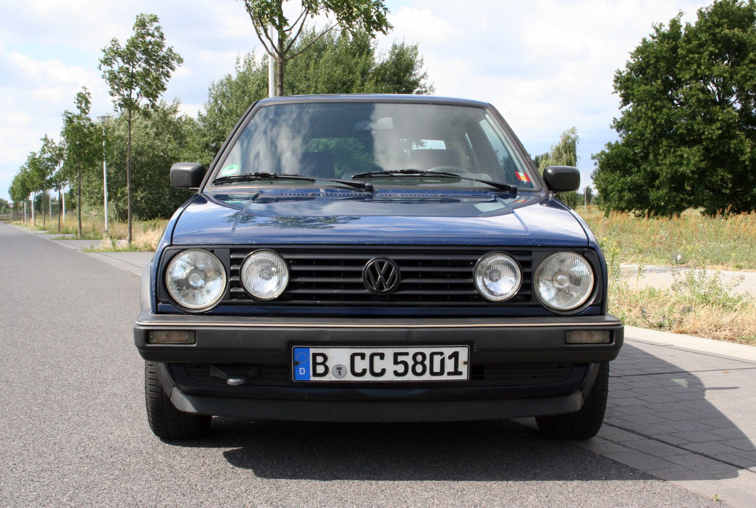 Front view with dual round headlights and black grille.