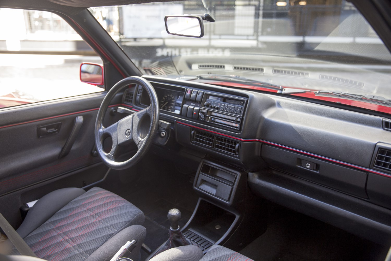 Vintage car interior with dashboard, manual gear shift, and fabric seats