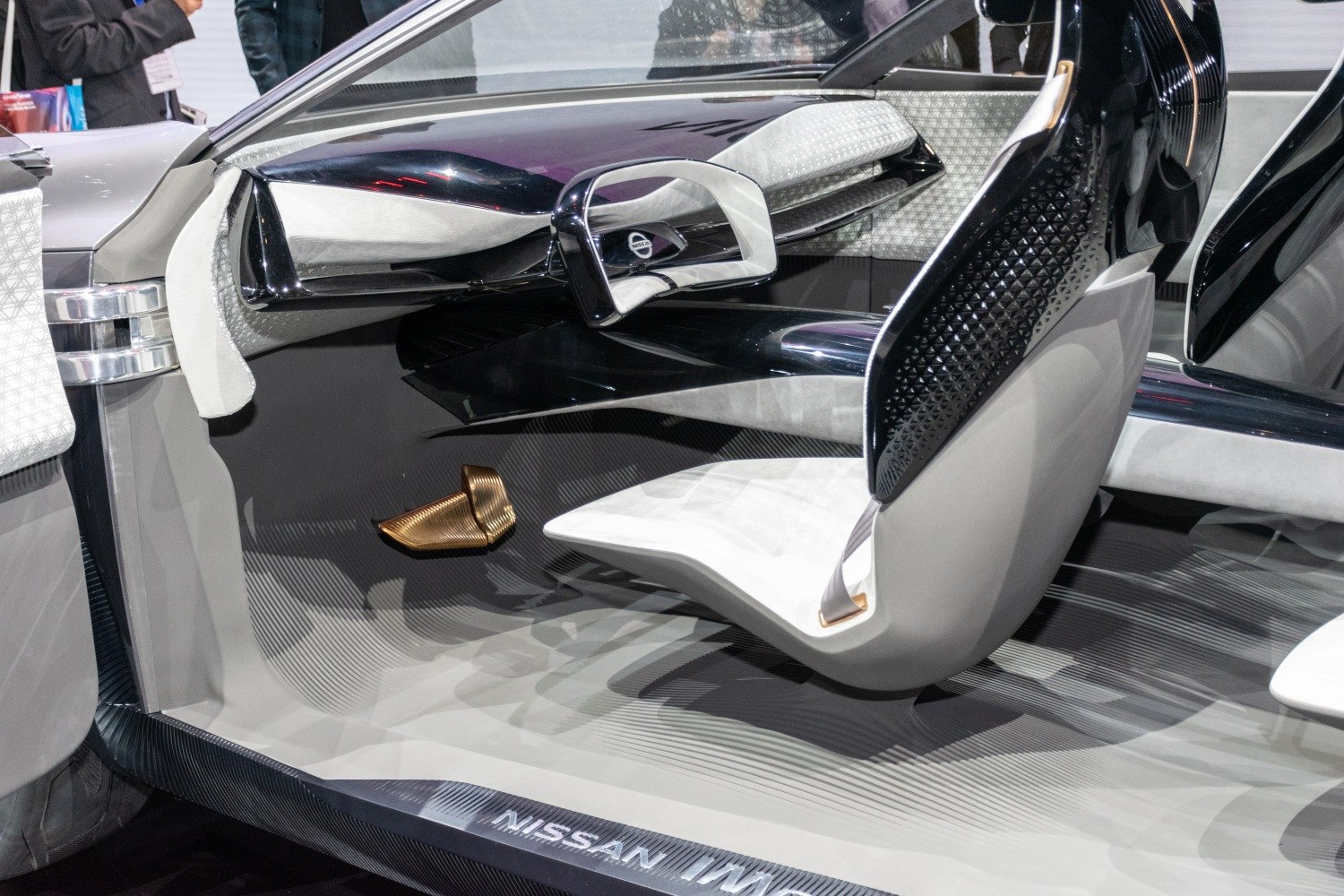 Futuristic minimalistic car interior with unique steering design and advanced materials.