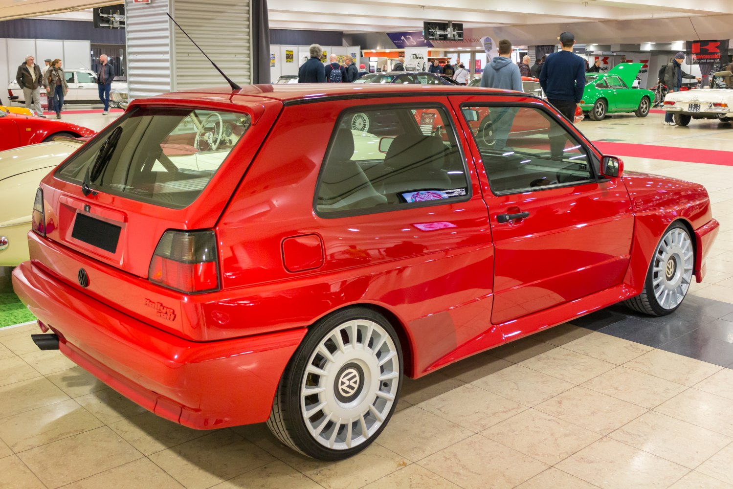 Red Volkswagen hatchback with aggressive body kit and alloy wheels