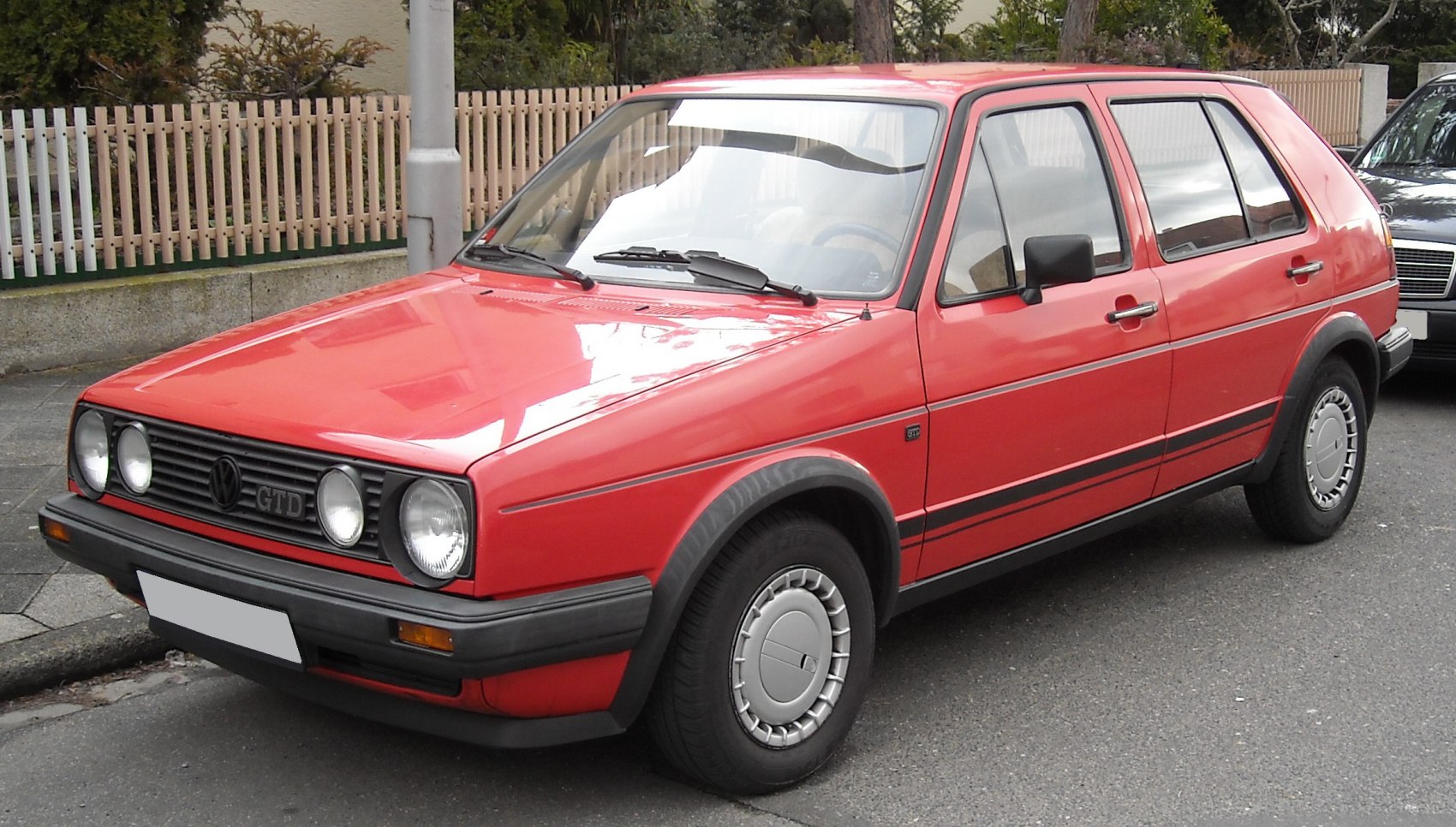 Red 5-door hatchback with round headlights and classic front grille
