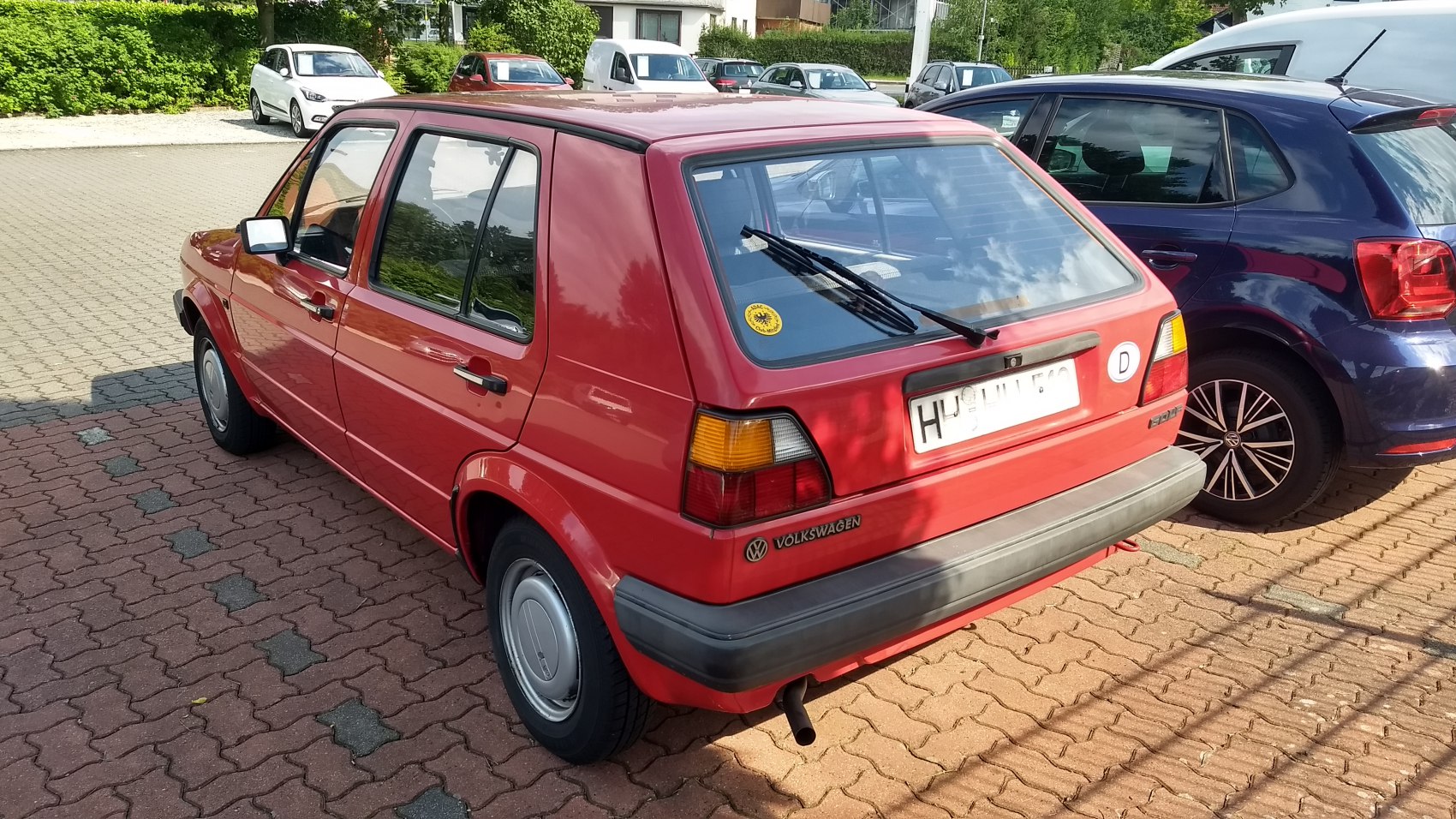 Red 5-door hatchback with rear windshield wiper and black trim