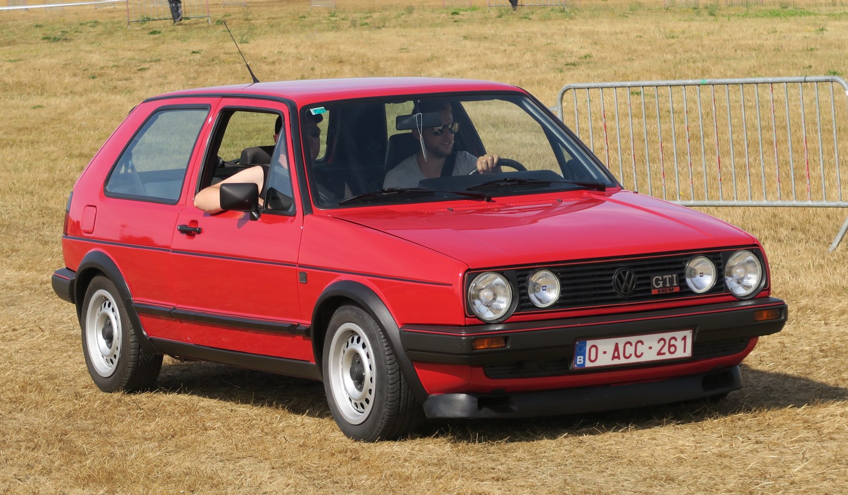 Red 3-door hatchback with round headlights and black trim.