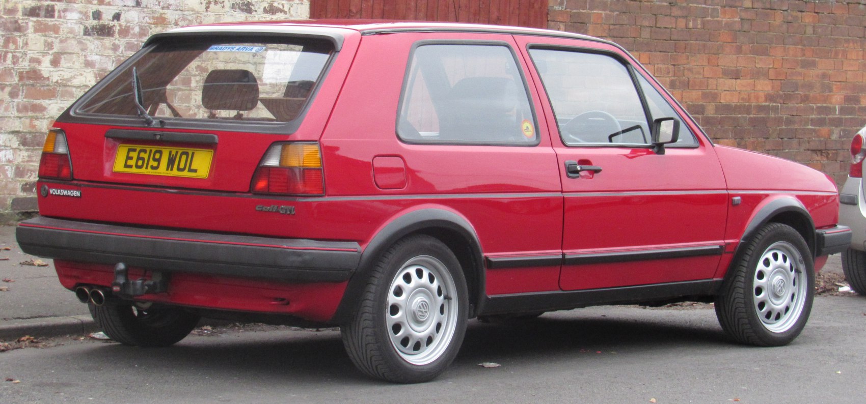 Red 3-door hatchback viewed from rear side