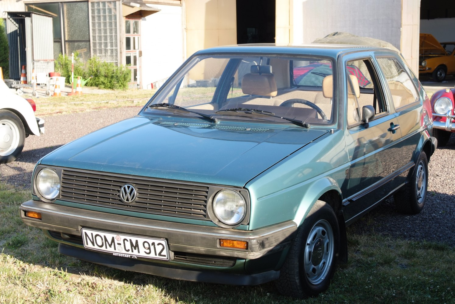 Front view of a classic 3-door hatchback with round headlights and horizontal grille