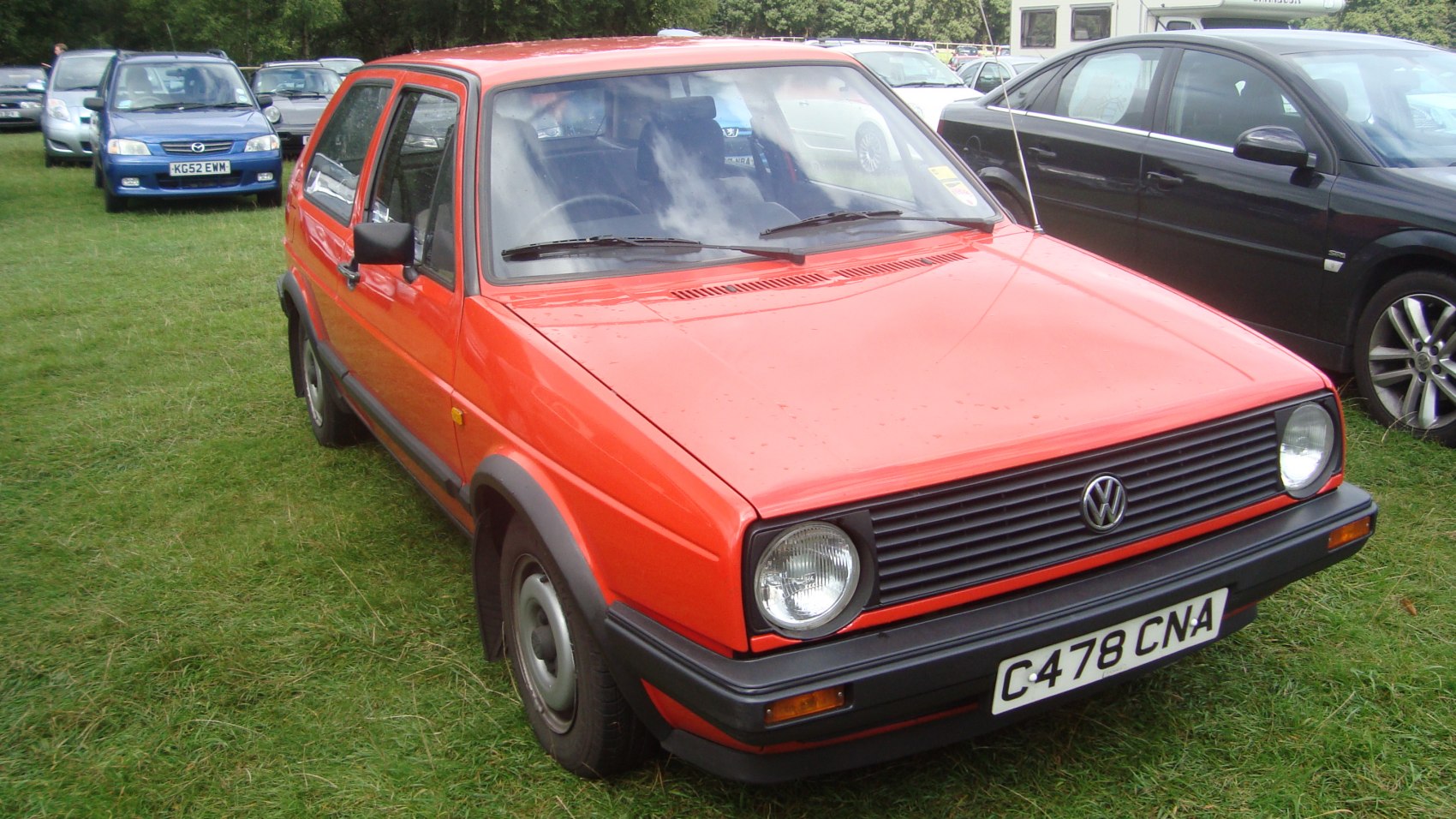 Red 3-door hatchback with square headlights and black grille front end
