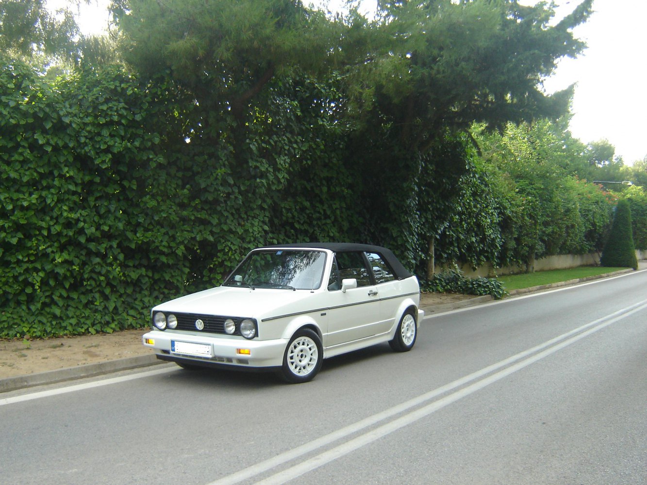 Classic white convertible with round headlights and black soft top