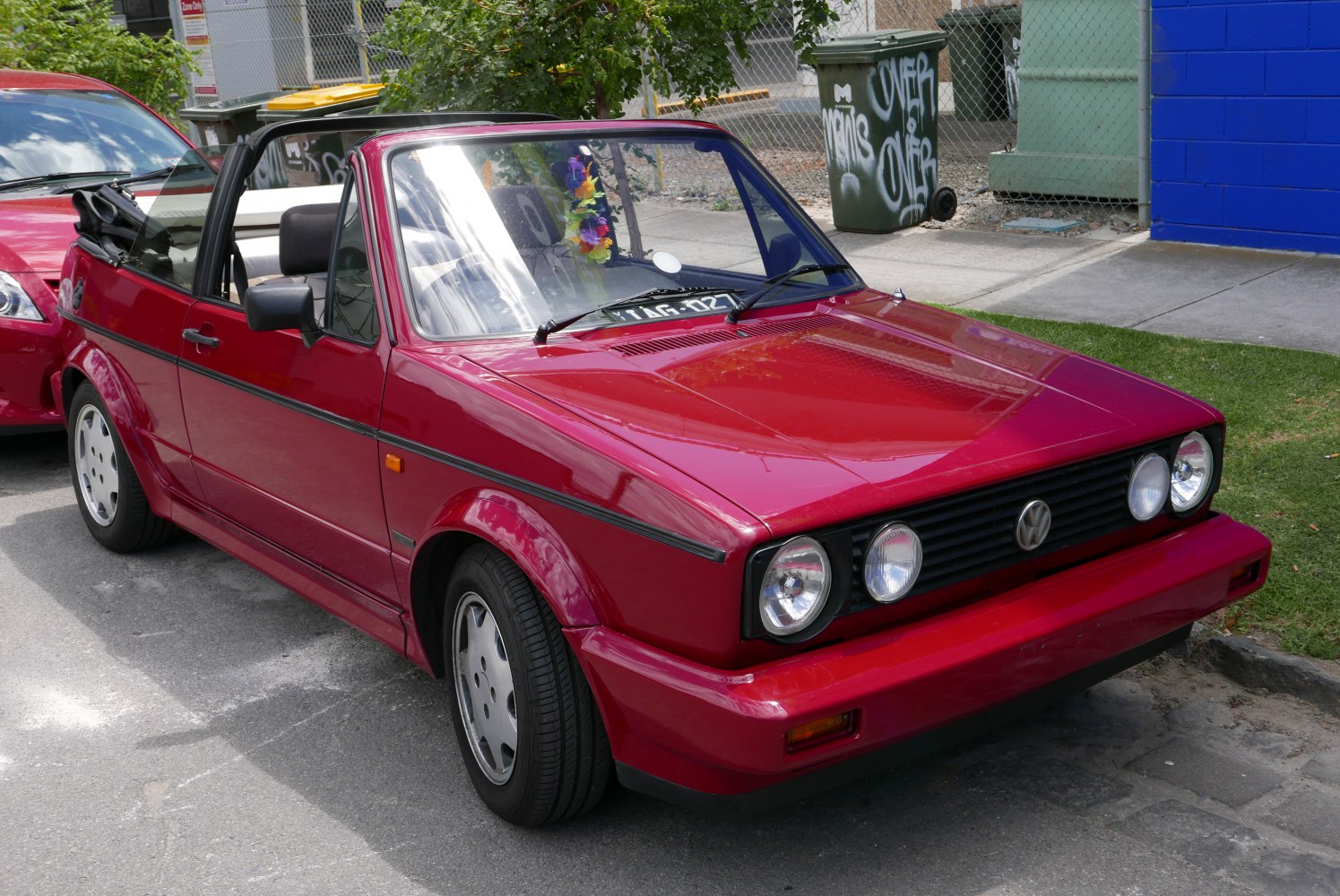 Convertible car with dual round headlights and lowered soft top