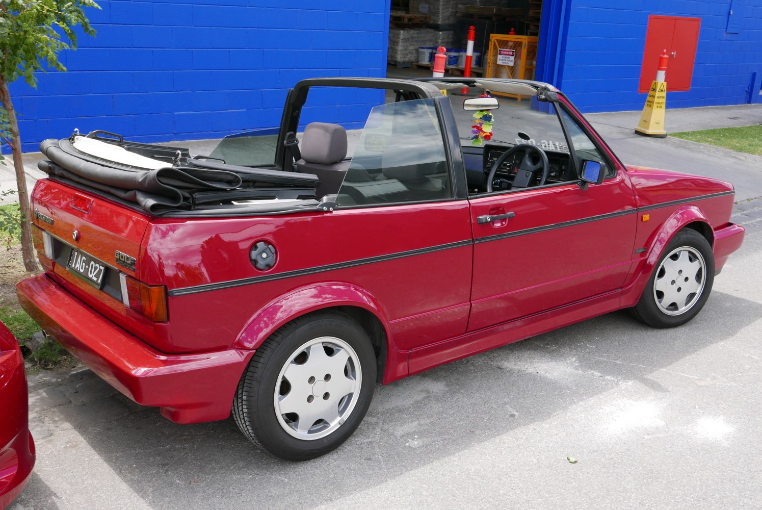 Red convertible with folded soft top roof and sporty compact design