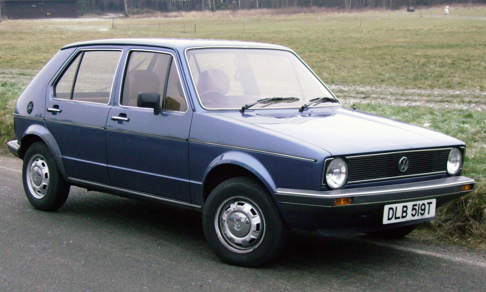 Front side view of vintage 5-door hatchback with round headlights and steel wheels