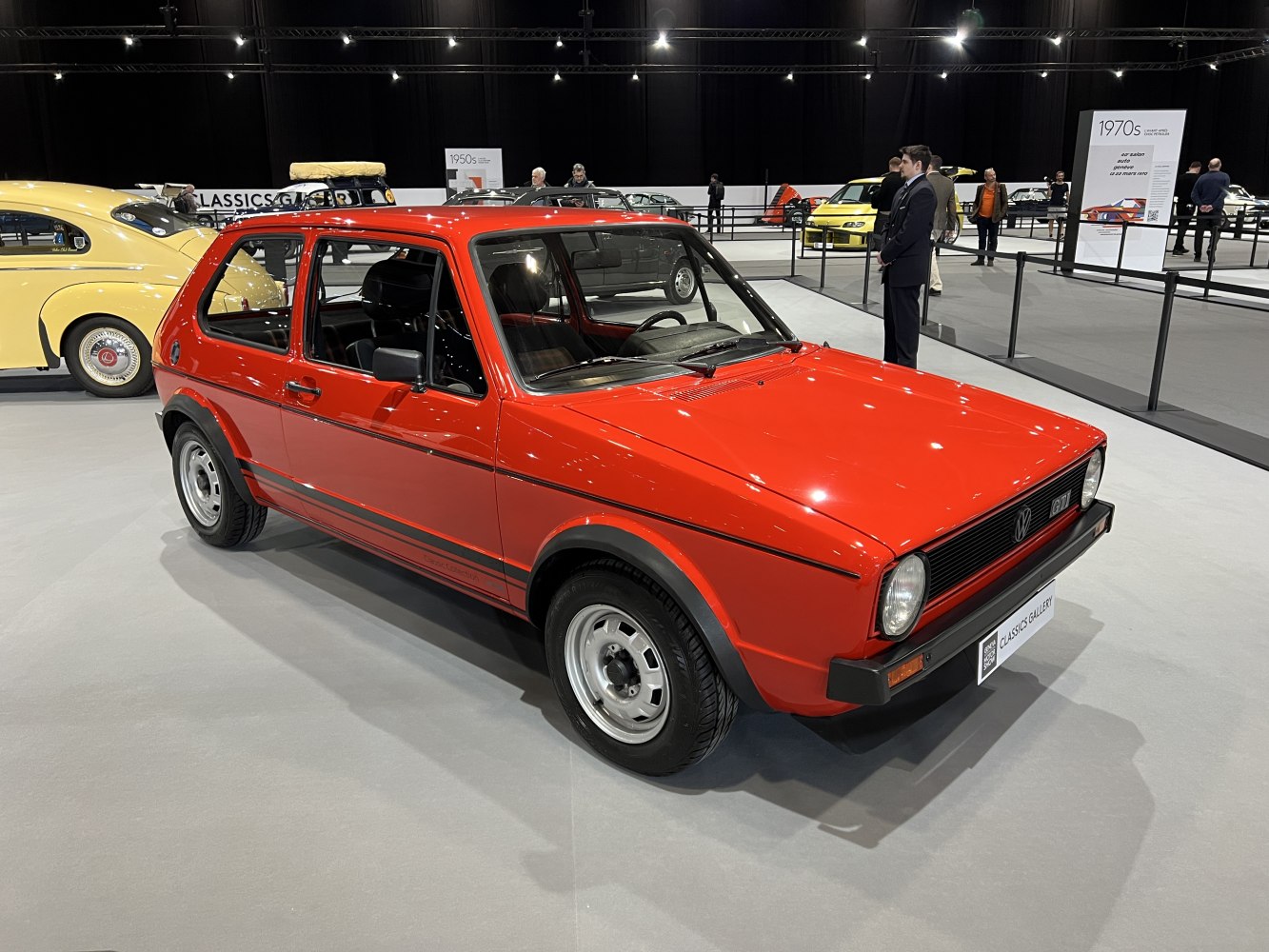 Red compact hatchback with round headlights and 3-door body style