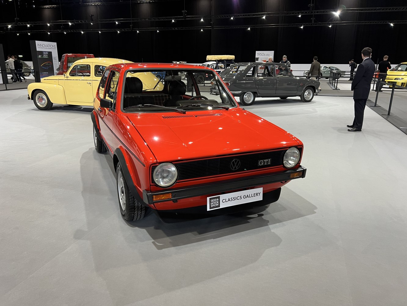 Red classic three-door hatchback with round headlights and black grille