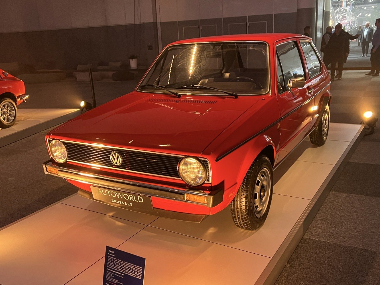 Red vintage compact 3-door hatchback with round headlights and chrome trim