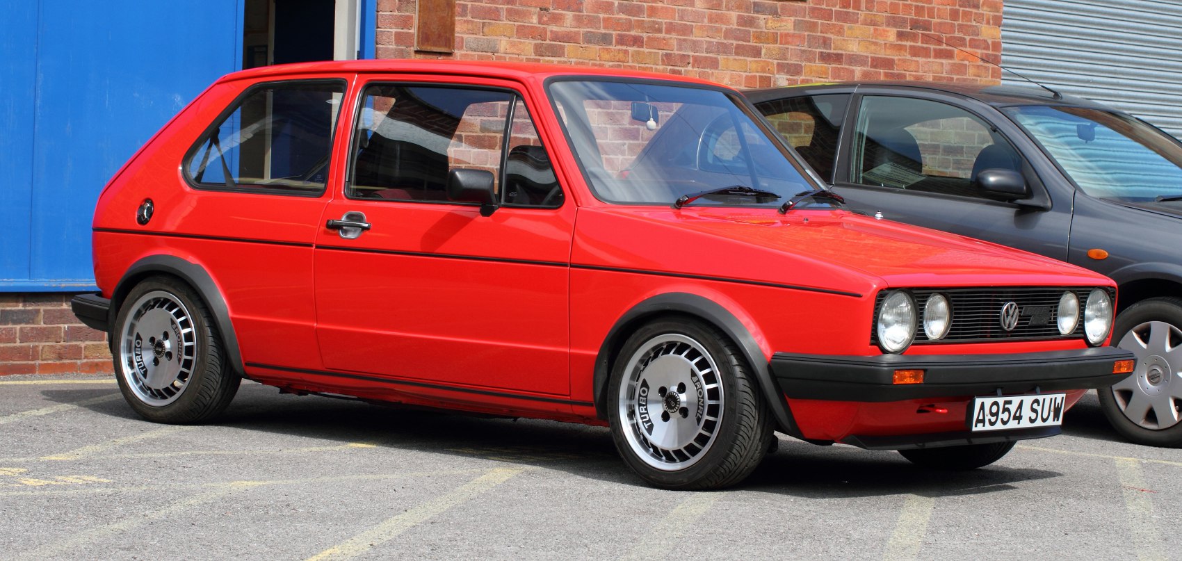 Red vintage 3-door hatchback with turbo alloy wheels.