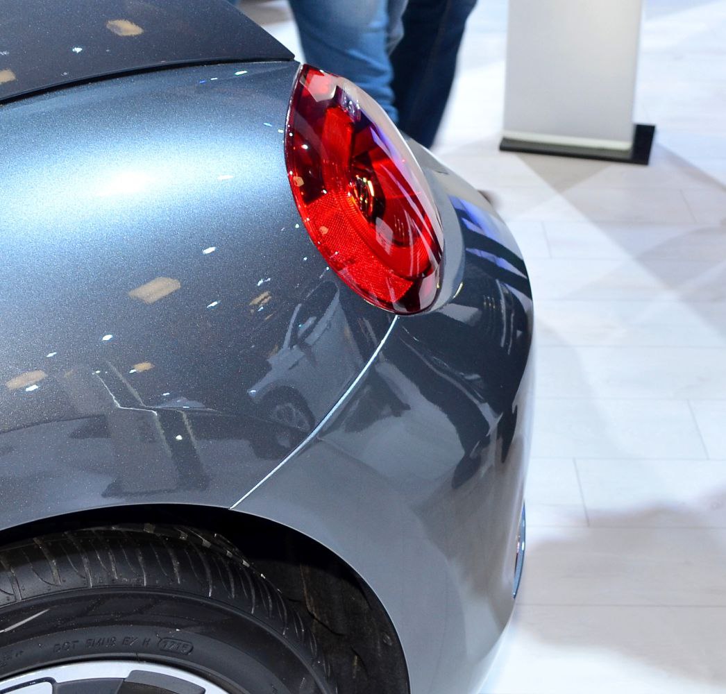 Red tail light and rear fender close-up with wheel arch and body reflections
