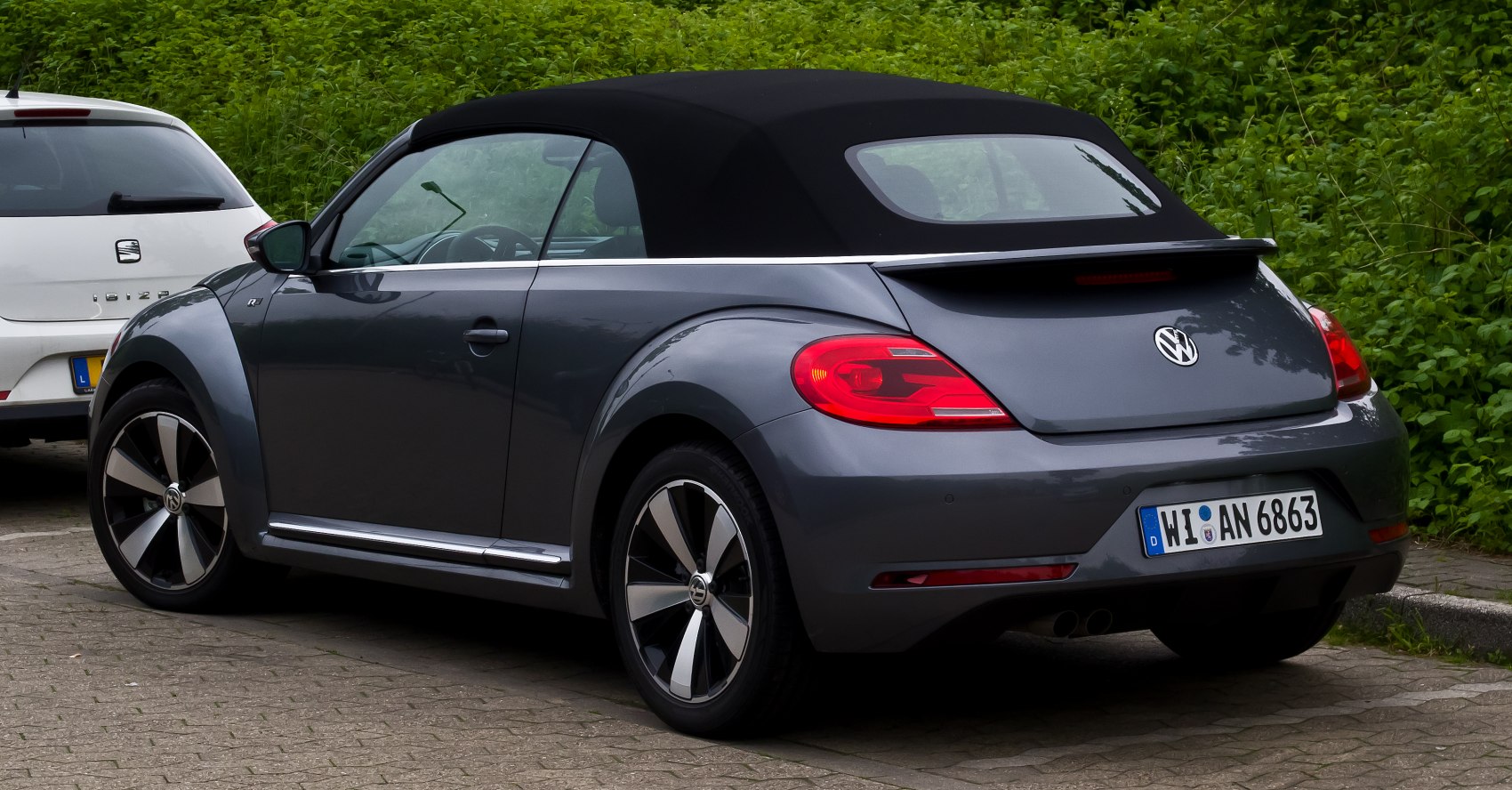 Rear view of a gray convertible with black soft top and modern alloy wheels.