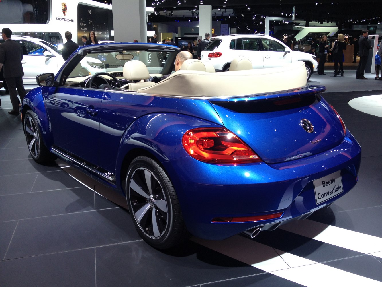 Blue convertible with beige soft top and multi-spoke alloy wheels