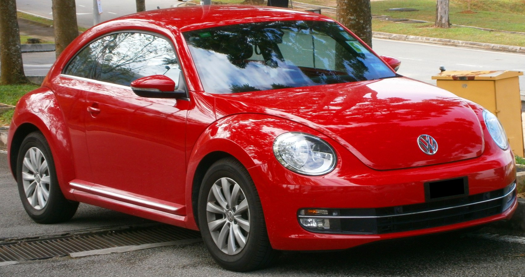 Front three-quarter view of red compact car with rounded design and modern headlights