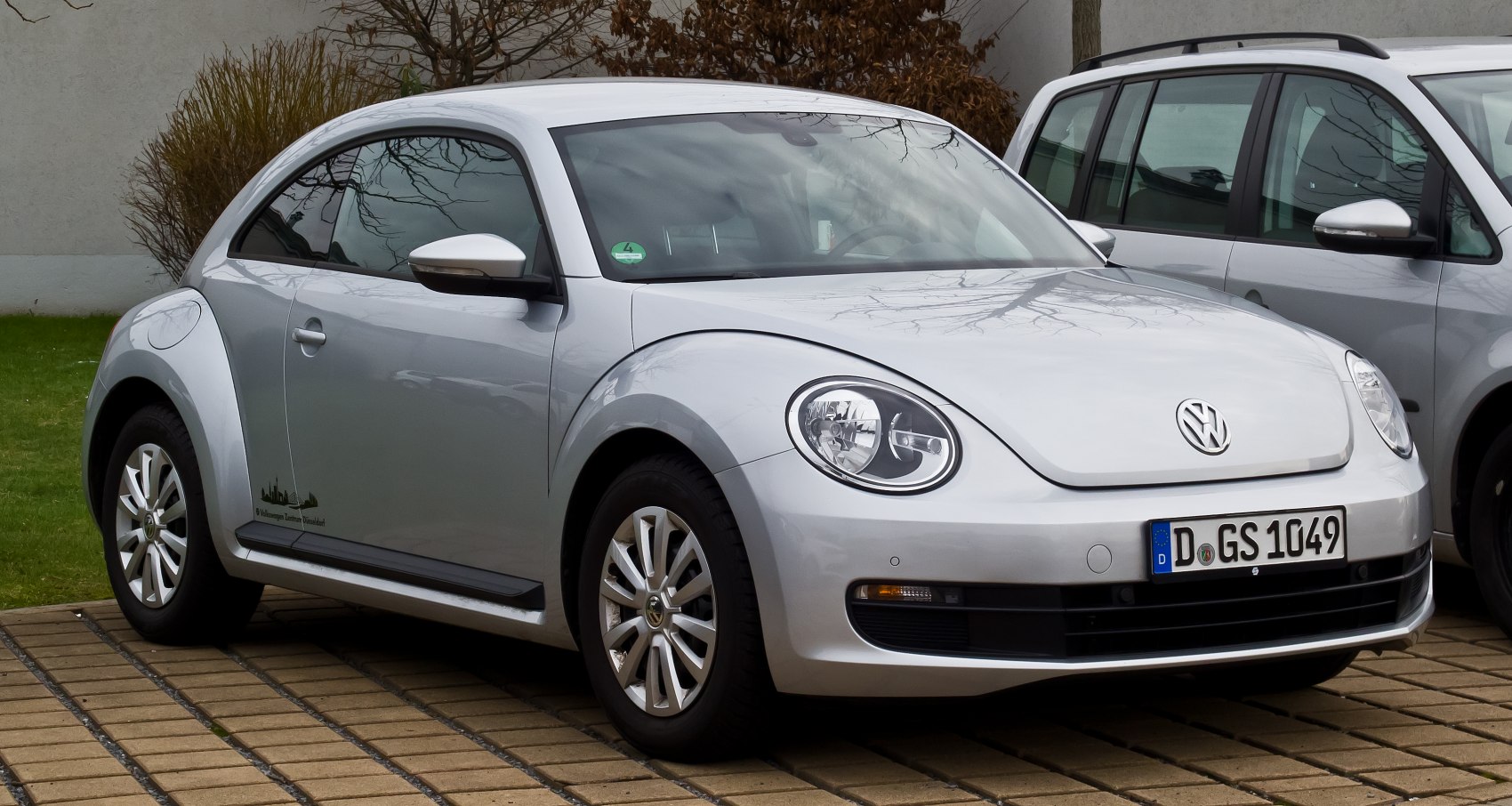 Silver compact car with rounded headlights and curved body front-three-quarter view