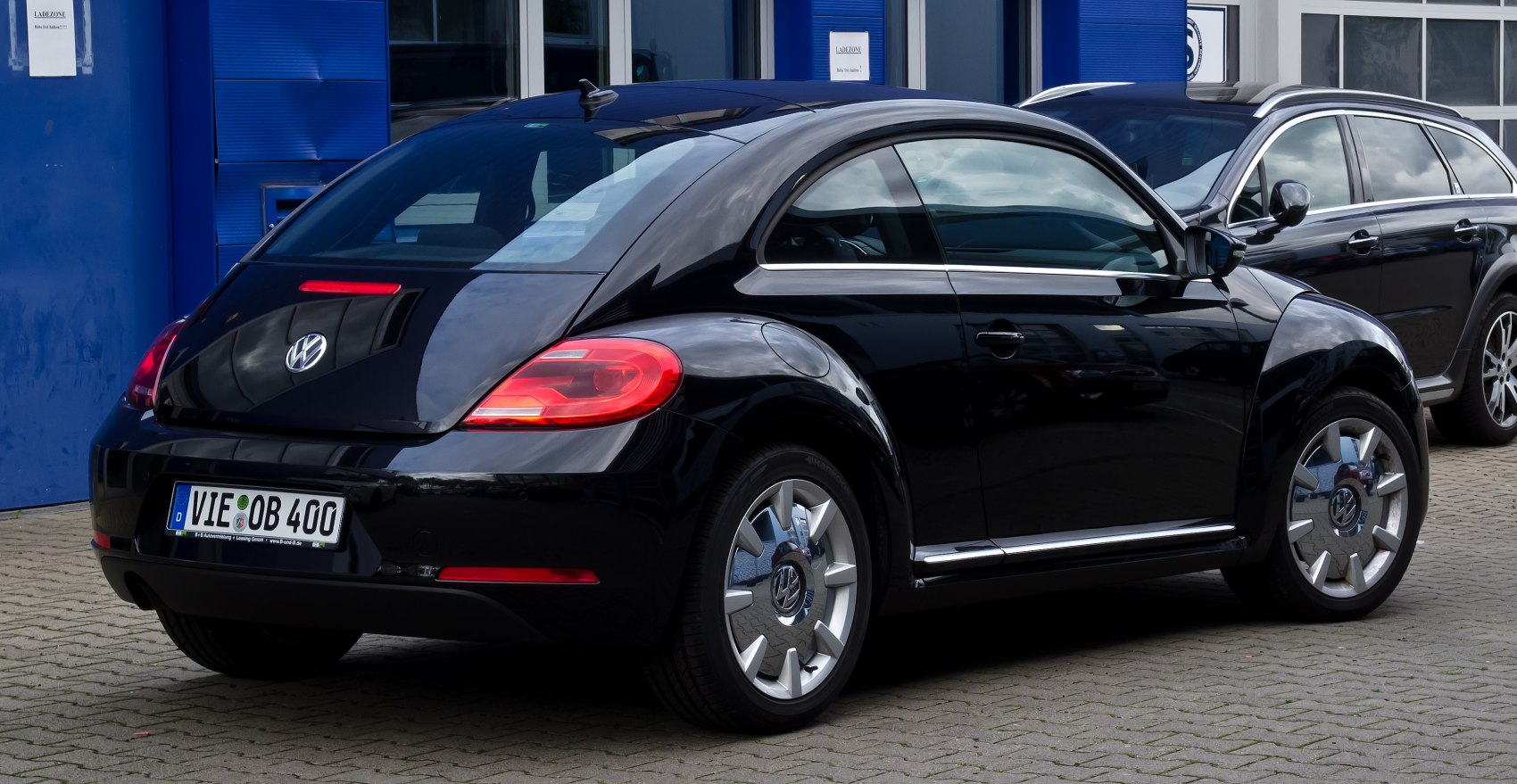 Rear side view of black car with rounded design and unique alloy wheels