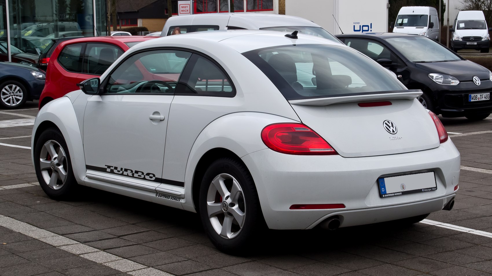 White coupe with rear spoiler and turbo decal