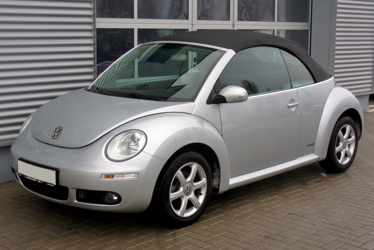 Silver convertible with black soft top and alloy wheels.