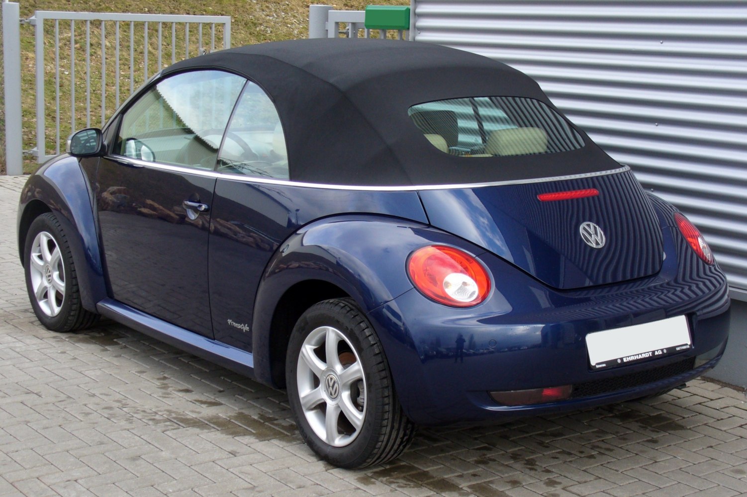 Rear view of convertible with black soft top and rounded taillights