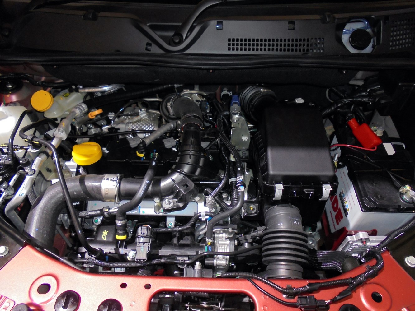 Close-up view of engine bay with hoses, battery, air intake components