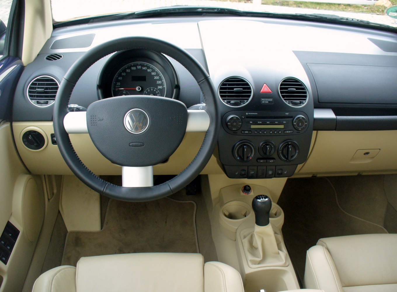 Steering wheel, dashboard, and manual gear shift in beige interior