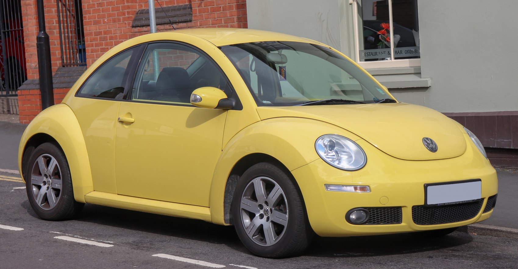 Yellow compact car with rounded headlights and alloy wheels