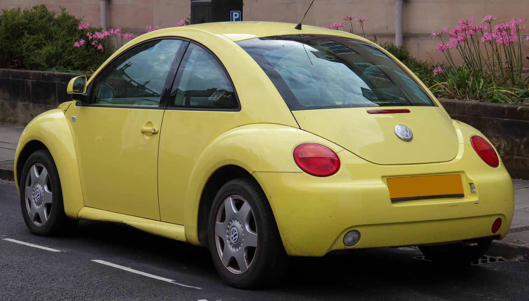 Yellow hatchback rear and side view with rounded fenders and taillights
