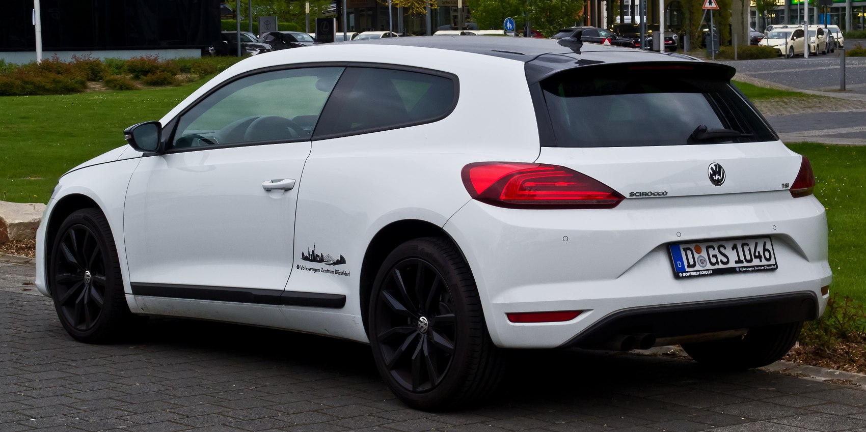 Rear side view with black alloy wheels of a white sporty hatchback