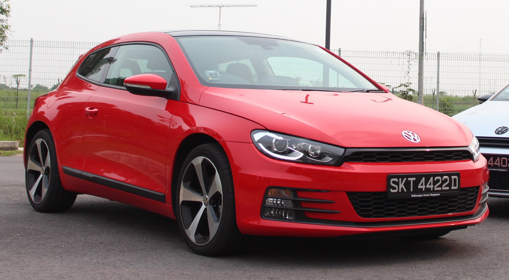 Red sporty hatchback with distinct headlights and black alloy wheels.
