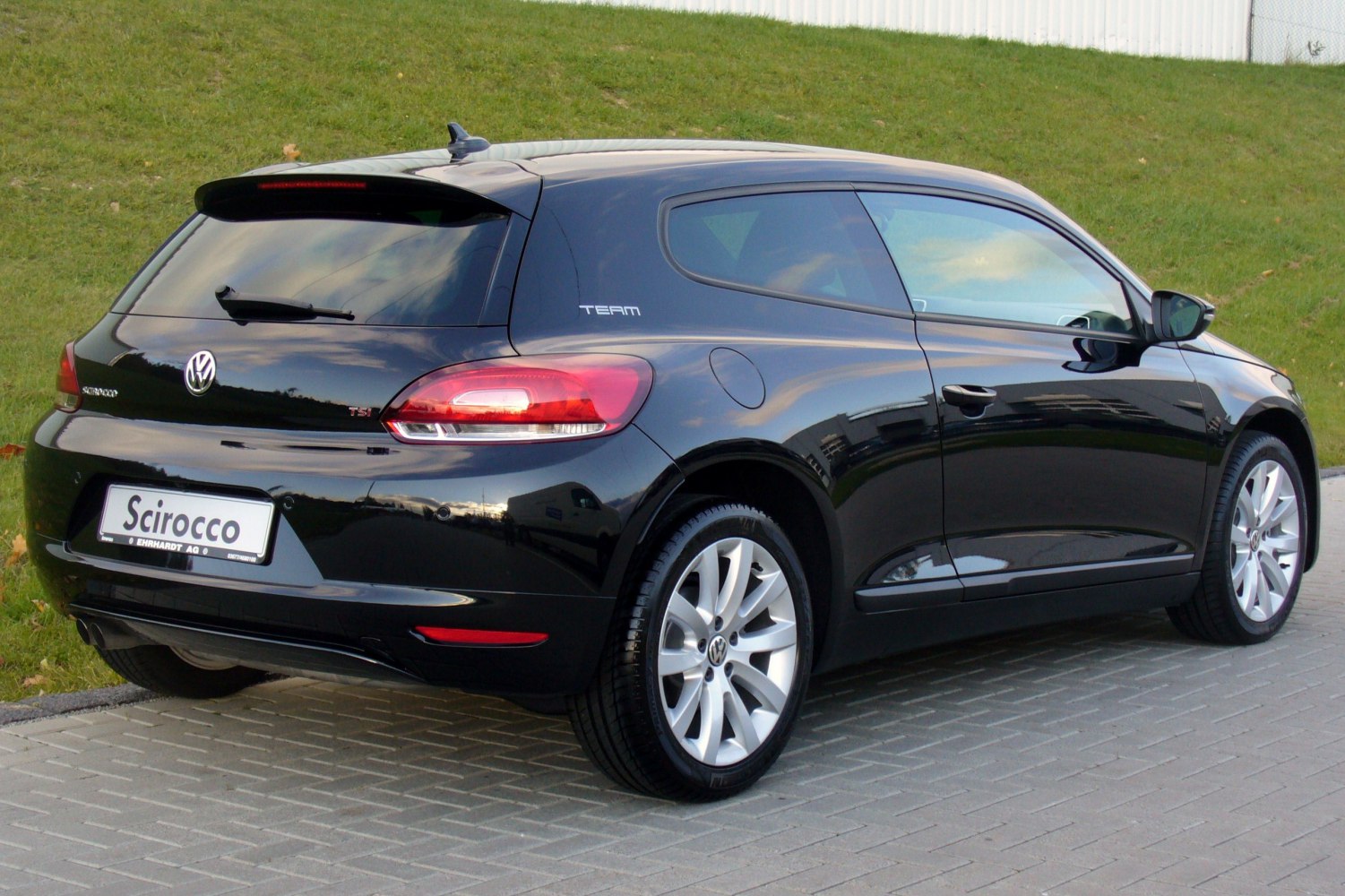 Black hatchback rear-side view with alloy wheels and tinted windows
