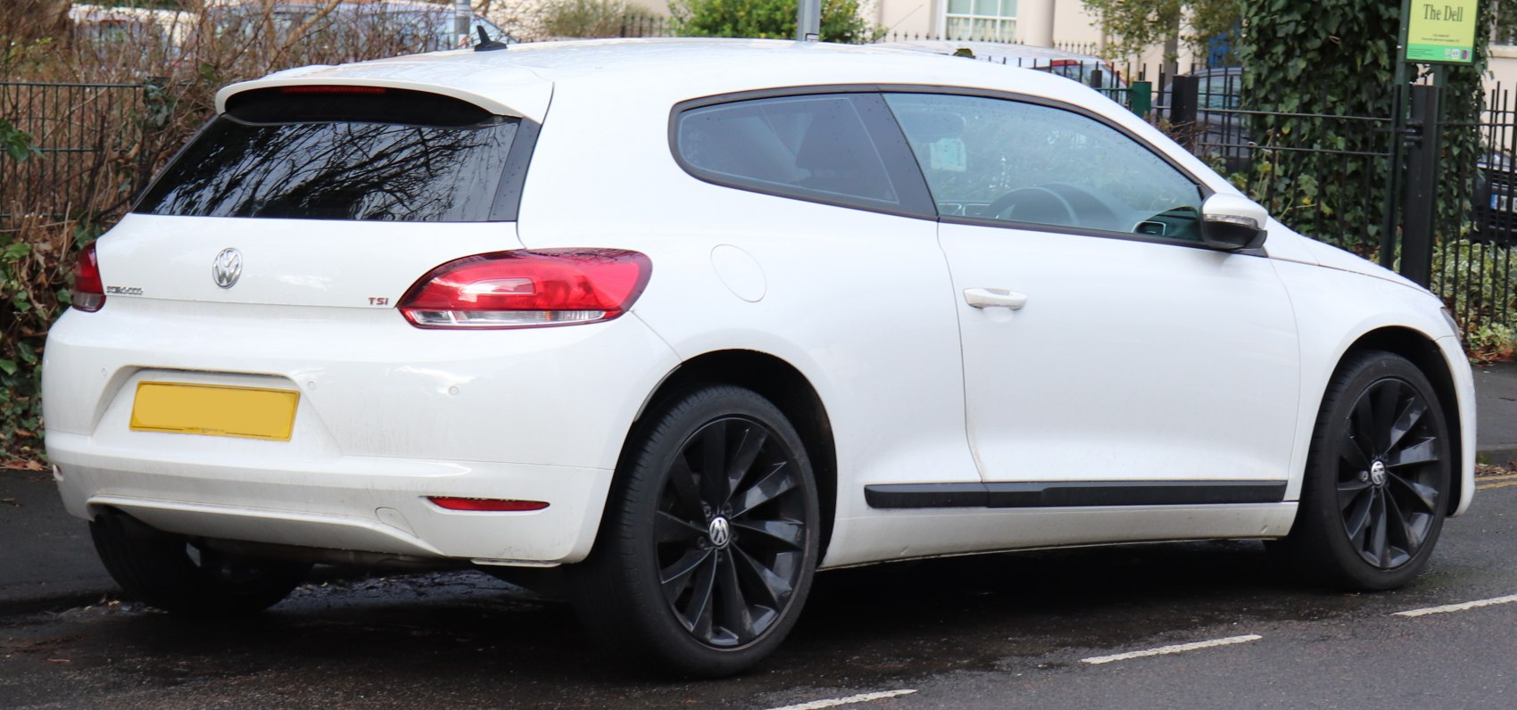 Rear and side view of white hatchback with black alloy wheels and tinted windows
