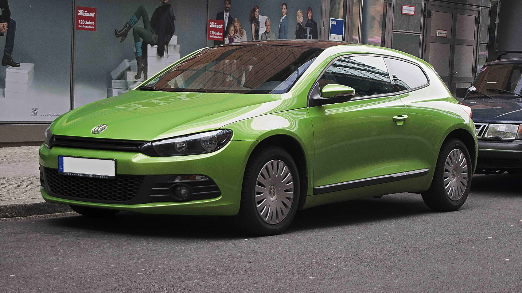 Green compact three-door hatchback with wide headlights and alloy wheel covers