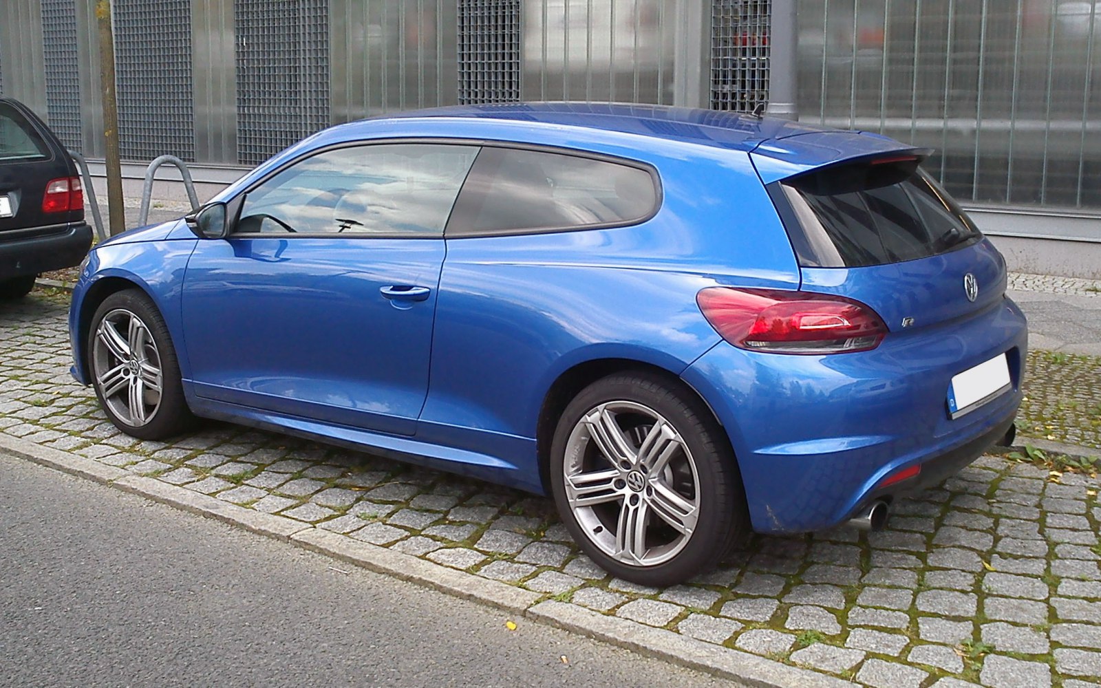 Blue 3-door coupe side and rear profile with alloy wheels