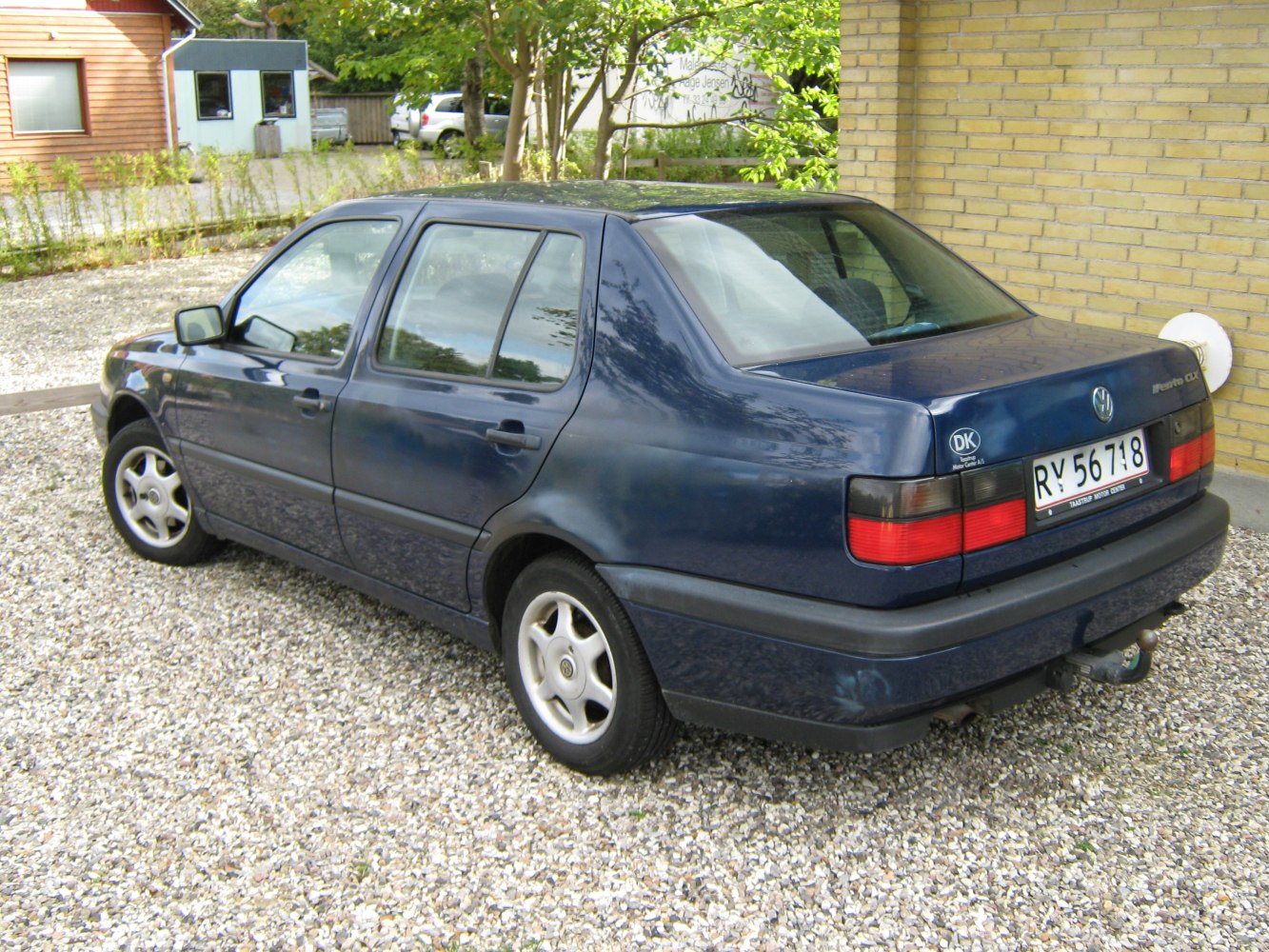 Dark blue compact sedan with alloy wheels and tow hitch