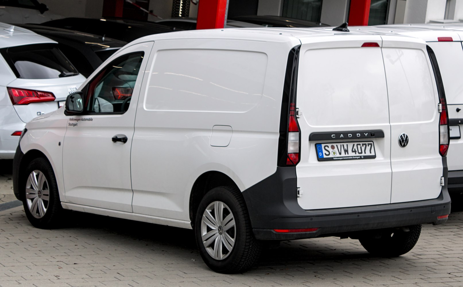 Rear view of white commercial panel van with vertical tail lights and closed cargo doors