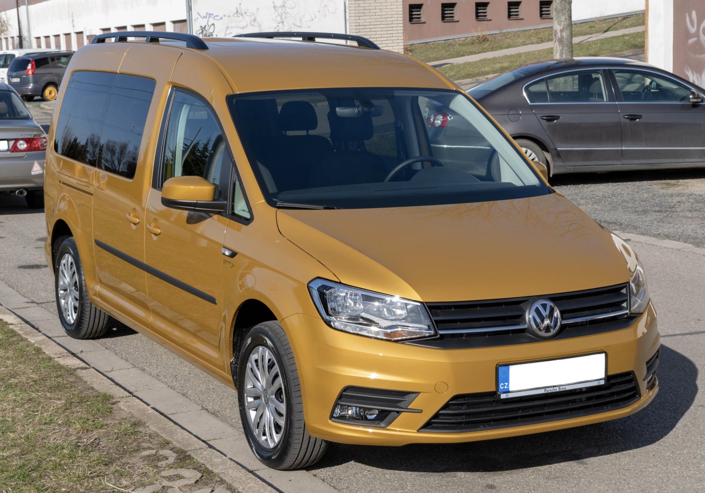 Front angled view of a compact yellow van with clear headlights and black grille